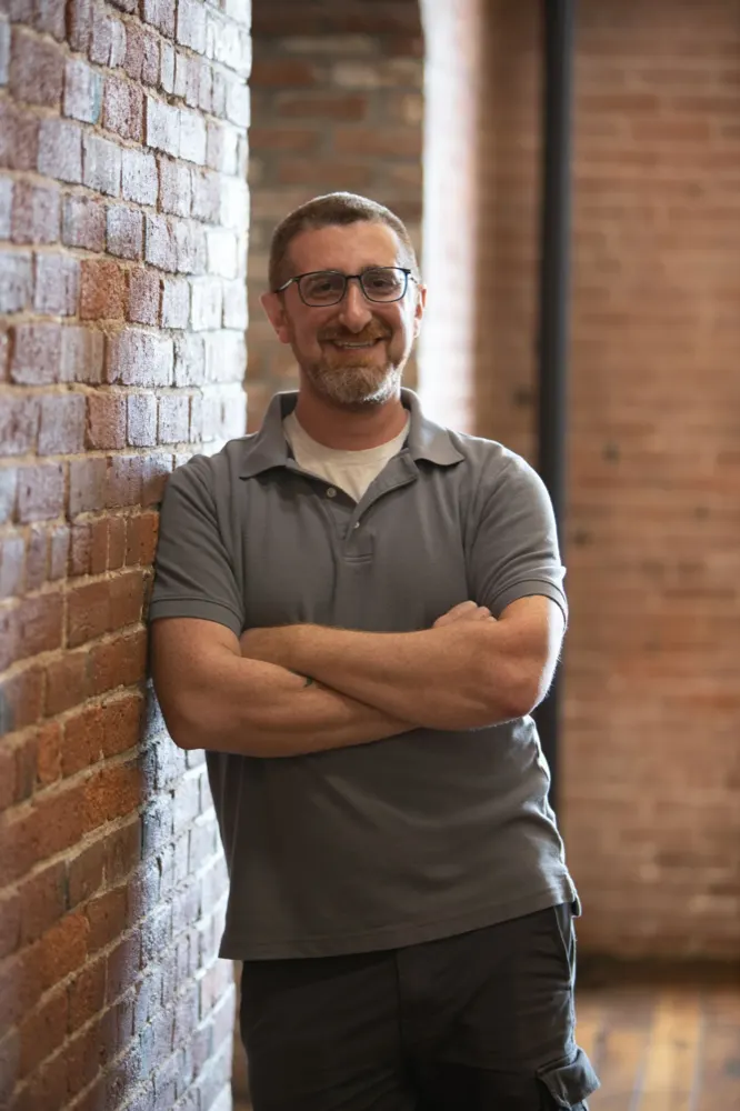 Timothy Walt, founder of CVW Financial, smiling with arms crossed against a brick wall